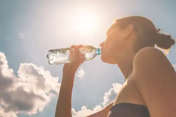 Hydration: The Secret Ingredient for a Toned Stomach and Enhanced Fitness 3 Image of woman drinking water to hydrate Nuneaton after run.
